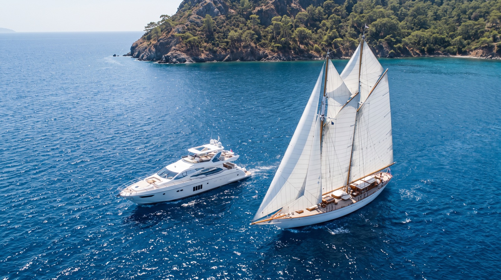 A motor yacht and a sailing yacht cruising side by side off the Turkish coast