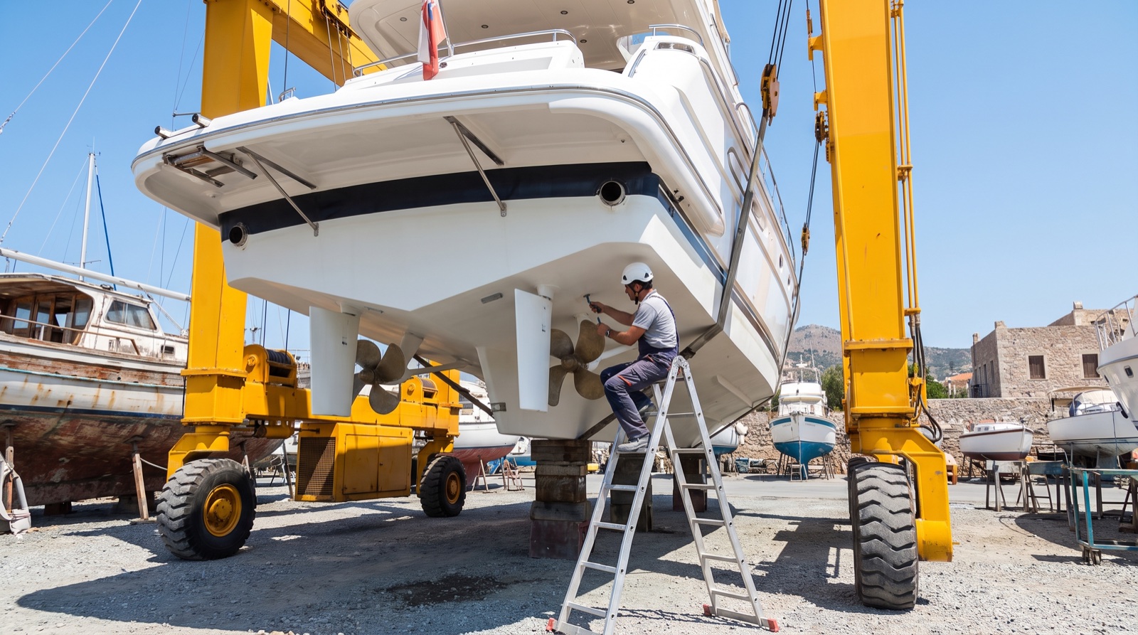 A yacht hull lifted out of the water for survey in a boatyard